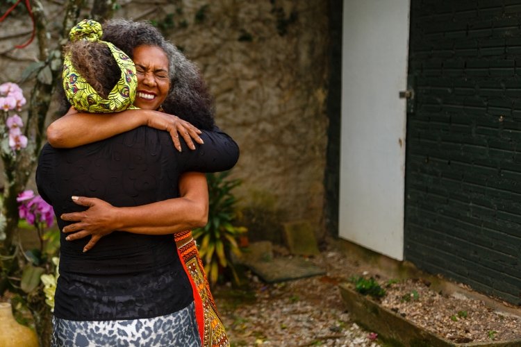 Two women hug; they have cultivated a deep friendship in midlife.