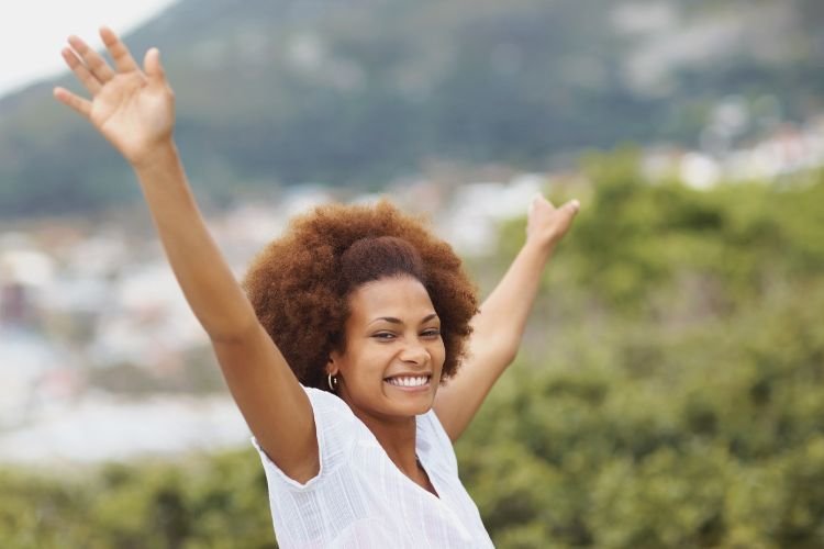 A woman spreads her arms in joy as she masters the art of letting go.