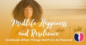 A woman stands in the kitchen with both of her hands over her heart as she practices gratitude to build midlife happiness and resilience.